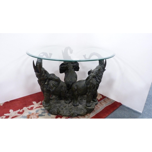 319 - Contemporary glass coffee table on three elephant supports.