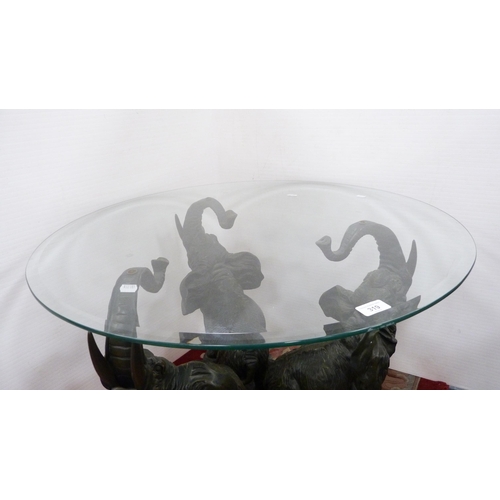 319 - Contemporary glass coffee table on three elephant supports.