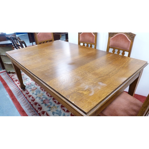 332 - Oak extending dining table and a set of six Art Nouveau-style oak dining chairs, with later upholste... 