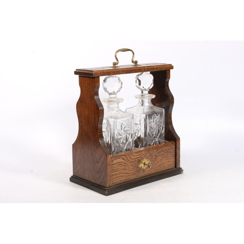 13 - Two bottle tantalus containing two cut glass decanters with stoppers.