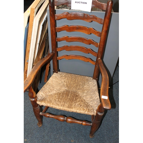 712 - Ladder backed country armchair with rush seat, 110cm tall.