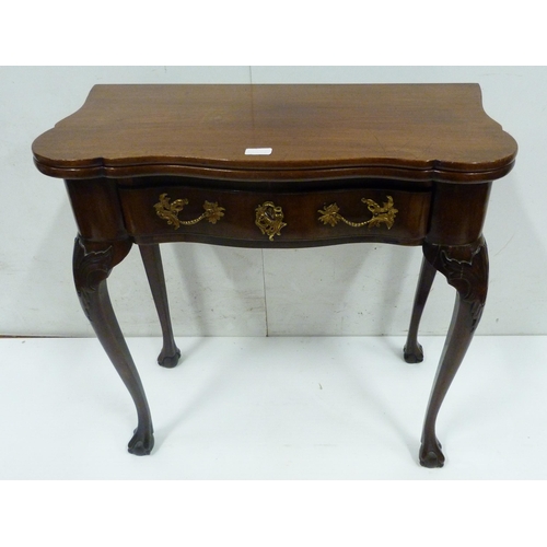 412 - George II style mahogany fold-over card table, on twin gate supports with central drawer, on ball an... 