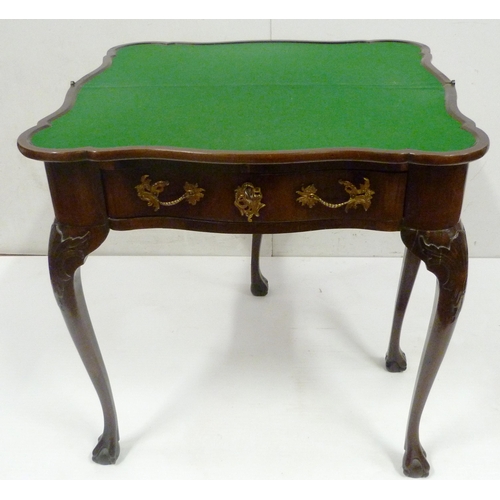 412 - George II style mahogany fold-over card table, on twin gate supports with central drawer, on ball an... 