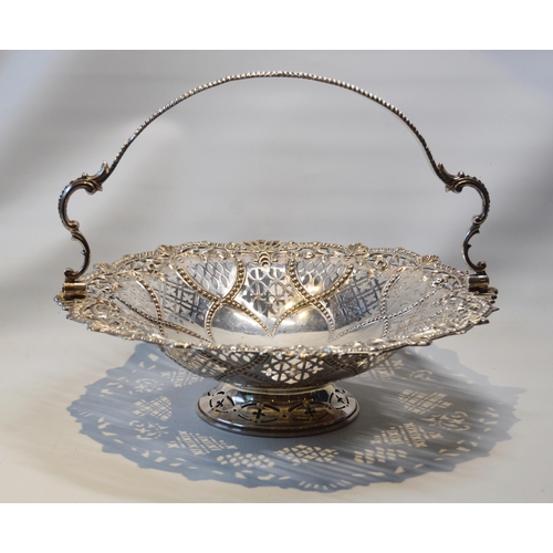 18 - Silver circular cake basket with swing handle, pierced and embossed, by Harrison & Howson, Sheff... 