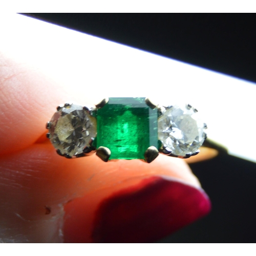 107 - Diamond and emerald three-stone ring, the brilliants approximately .3ct each, total diamond content ... 