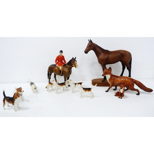 231 - Beswick porcelain hunting group comprising a huntsman on horseback, five hounds and a seated fox, al... 