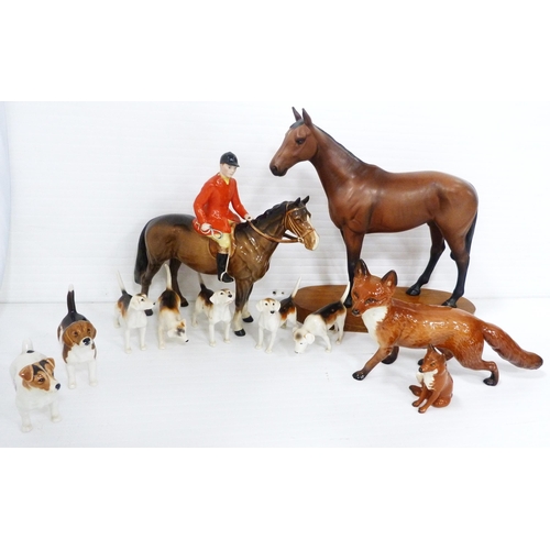 231 - Beswick porcelain hunting group comprising a huntsman on horseback, five hounds and a seated fox, al... 