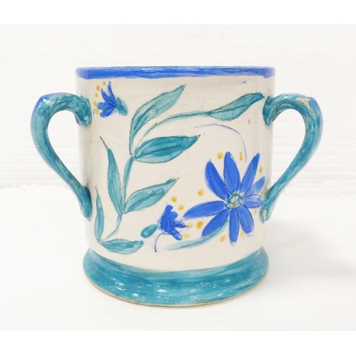 235 - Art pottery tyg hand-painted with floral motifs on a white field, glazed in a pale blue to handle, b... 