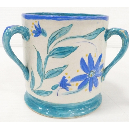 235 - Art pottery tyg hand-painted with floral motifs on a white field, glazed in a pale blue to handle, b... 