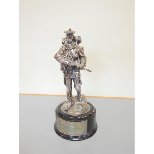 323 - White metal figure of a British soldier on an ebonized wooden base. The sterling silver plaque is in... 