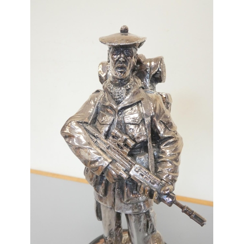 323 - White metal figure of a British soldier on an ebonized wooden base. The sterling silver plaque is in... 