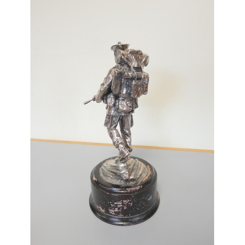 323 - White metal figure of a British soldier on an ebonized wooden base. The sterling silver plaque is in... 