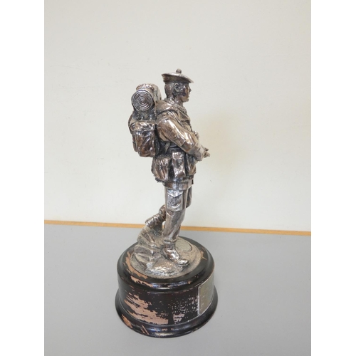 323 - White metal figure of a British soldier on an ebonized wooden base. The sterling silver plaque is in... 