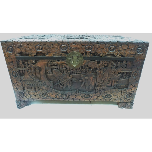 428 - Oriental carved camphorwood blanket chest (20th century), the hinged top profusely carved with figur... 