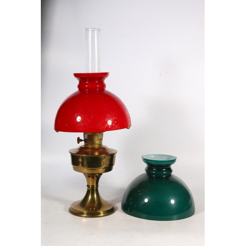 44 - Brass oil lamp with red glass shade, and a green glass shade.