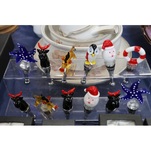 64 - Edzard novelty glass bottle stoppers and stand.