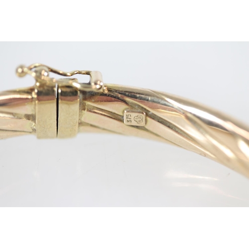 500 - 9ct gold hoop hinged bangle, 9.0g.