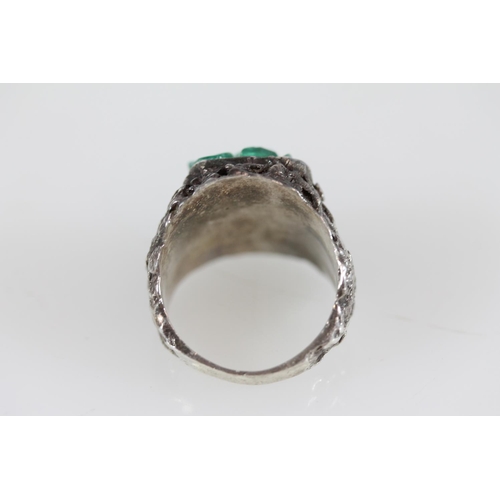 502 - Modernist silver ring with uncut green stones set within a textured band, size R.