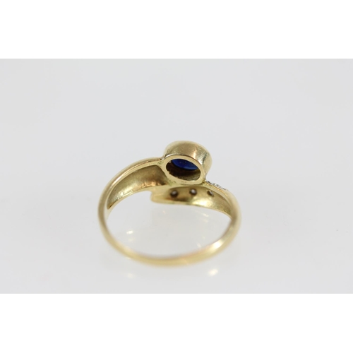 506 - Yellow metal ring set with oval sapphire and diamond chips, size H, 2.2g, tests as 18ct.