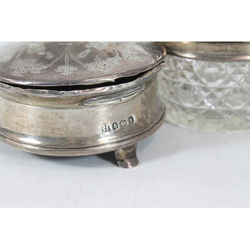 555 - Pair of hallmarked weighted silver candlesticks and two silver dressing table jars.