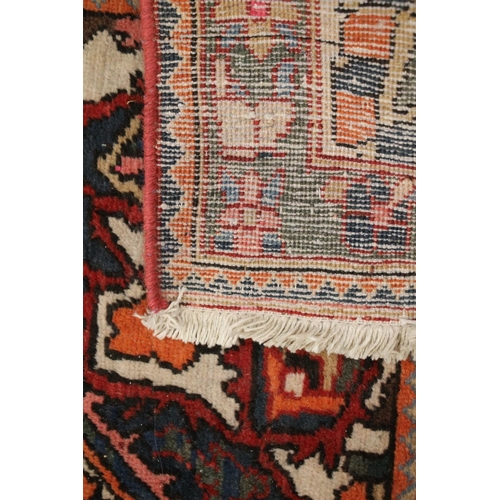 685 - Large Persian carpet in reds and polychrome decoration, 310cm x 210cm.