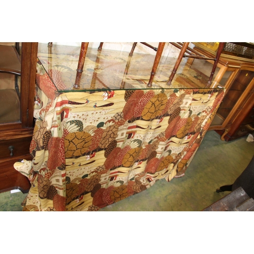 599 - Glass topped cabinet with Indian embroidered tablecloth over.