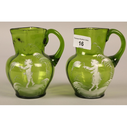 16 - Two green glass Mary Gregory jugs, each jug 13cm high