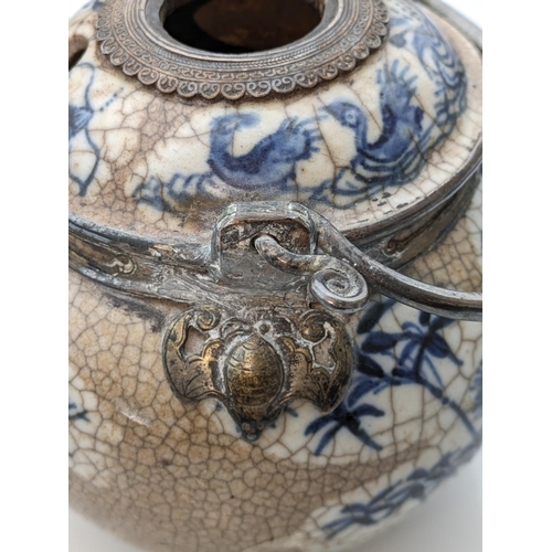 234 - Oriental blue and white pottery pot with metal handle and metal mounts in the form of hanging bats, ... 