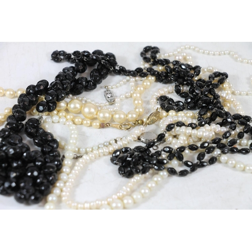 554 - Simulated pearl necklaces together with a French glass black beaded necklace