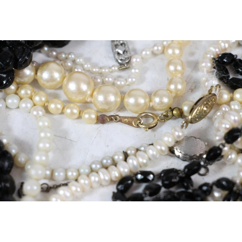 554 - Simulated pearl necklaces together with a French glass black beaded necklace