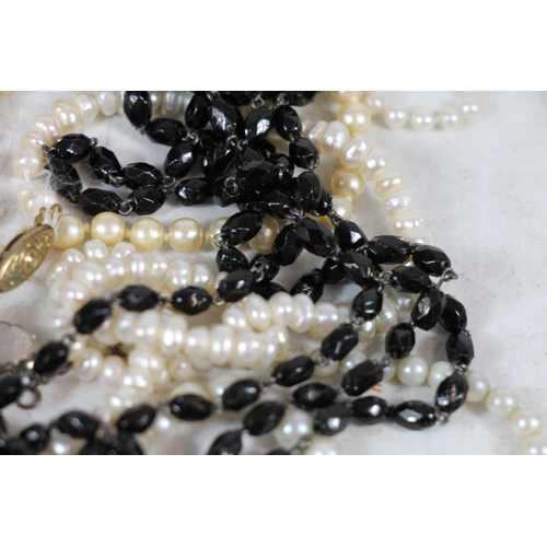 554 - Simulated pearl necklaces together with a French glass black beaded necklace