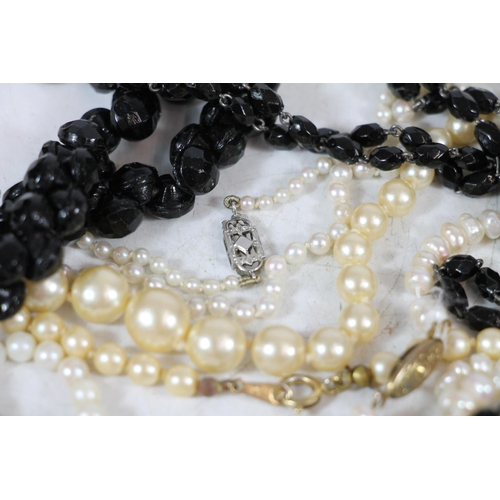 554 - Simulated pearl necklaces together with a French glass black beaded necklace