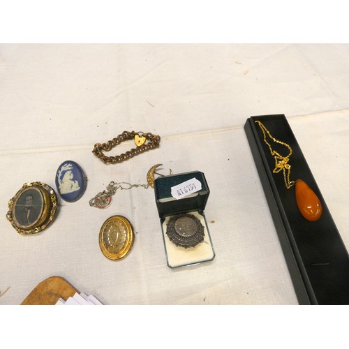 258 - Bag of vintage costume jewellery to include amber style necklace, brooches etc.