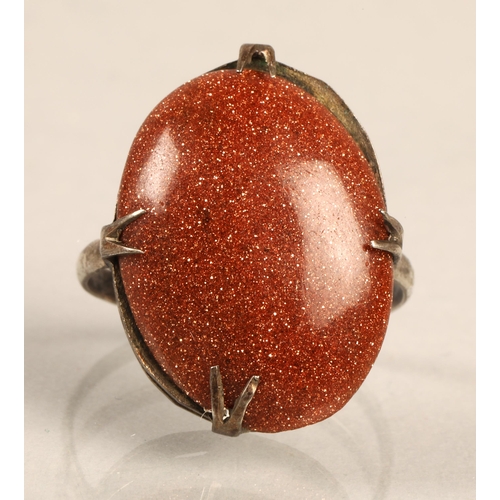 101 - White metal ring set with goldstone cabochon, ring size L/M