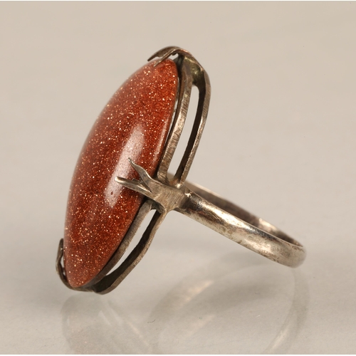 101 - White metal ring set with goldstone cabochon, ring size L/M