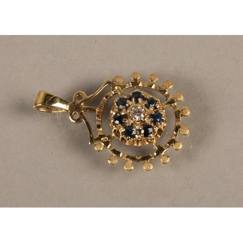 140 - 14K gold pendant set with a central diamond surrounded by blue gems, gross weight 2.5g