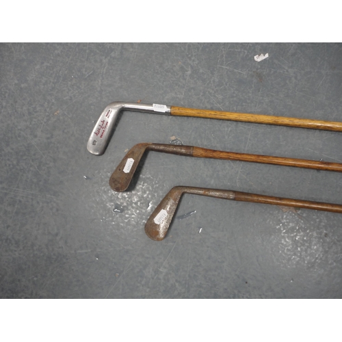 121 - Three hickory-shafted golf clubs to include a putter.