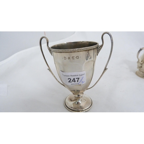 247 - Small silver twin-handled prize cup and a silver cream jug, 182g gross.  (2)