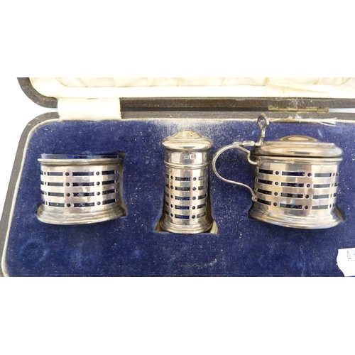 265 - Silver three-piece condiment set with blue glass liners, cased.