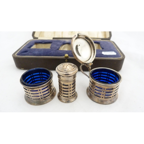 265 - Silver three-piece condiment set with blue glass liners, cased.