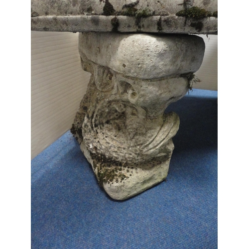 434 - Stone garden seat on repoussé fish pedestals.