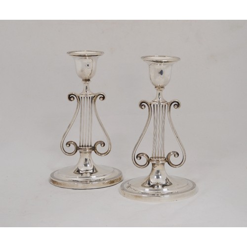 60 - Pair of silver table candlesticks with lyre stems, on oval bases, London and Sheffield 1902-09, 20cm... 