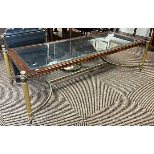 556 - Glazed coffee table with brass legs, approx. 143cm x 60cm 