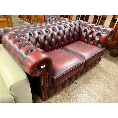 634 - Oxblood leather Chesterfield two seat settee (damaged)