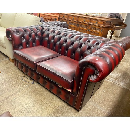 634 - Oxblood leather Chesterfield two seat settee (damaged)