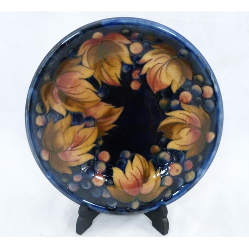 247 - Moorcroft leaf and berries design tube-lined dish on blue ground, stamped Moorcroft to the underside... 