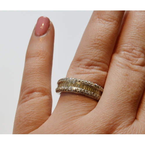 131 - Diamond half eternity ring with a band of baguettes flanked by bands of small brilliants, in 18ct wh... 