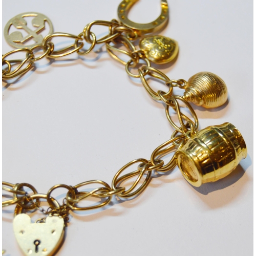 141 - 9ct gold padlock bracelet with dependant charms, marked '375' to most, 22g gross.