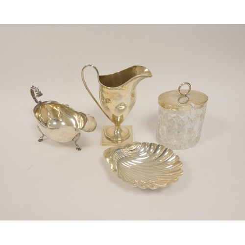 20 - Silver cream jug of helmet form, a cream boat, butter shell, and a glass preserve pot with silver li... 