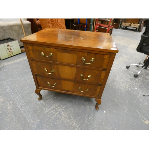 506 - Walnut style chest of three drawers on raised legs.